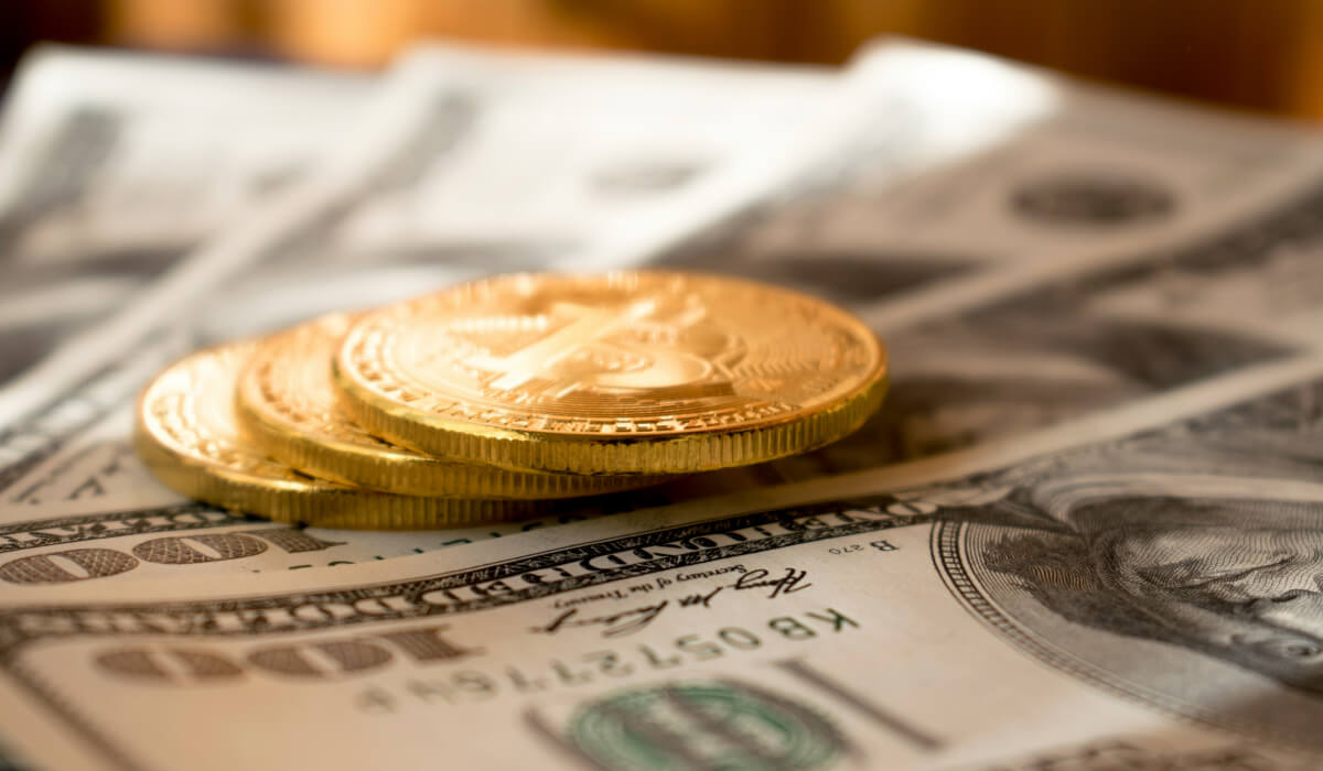 US dollar bills laid out on a table with coins representing various investments placed on top.