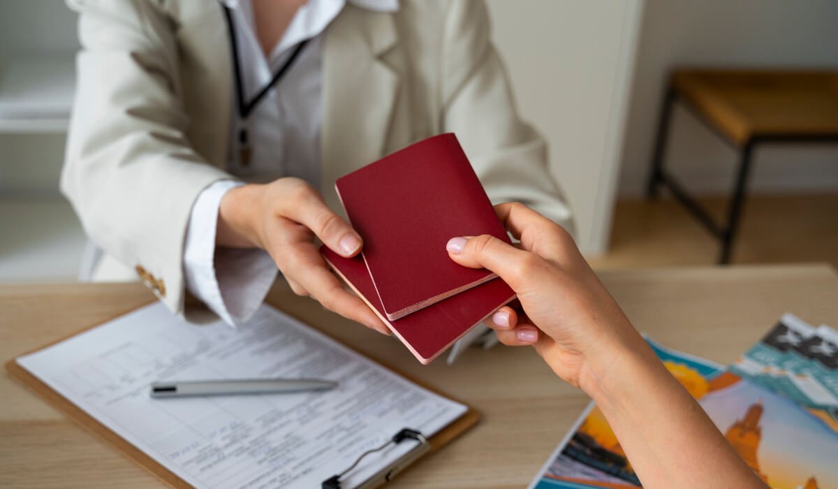 An immigration officer handing two passports to an applicant, symbolizing the completion of the immigration process.