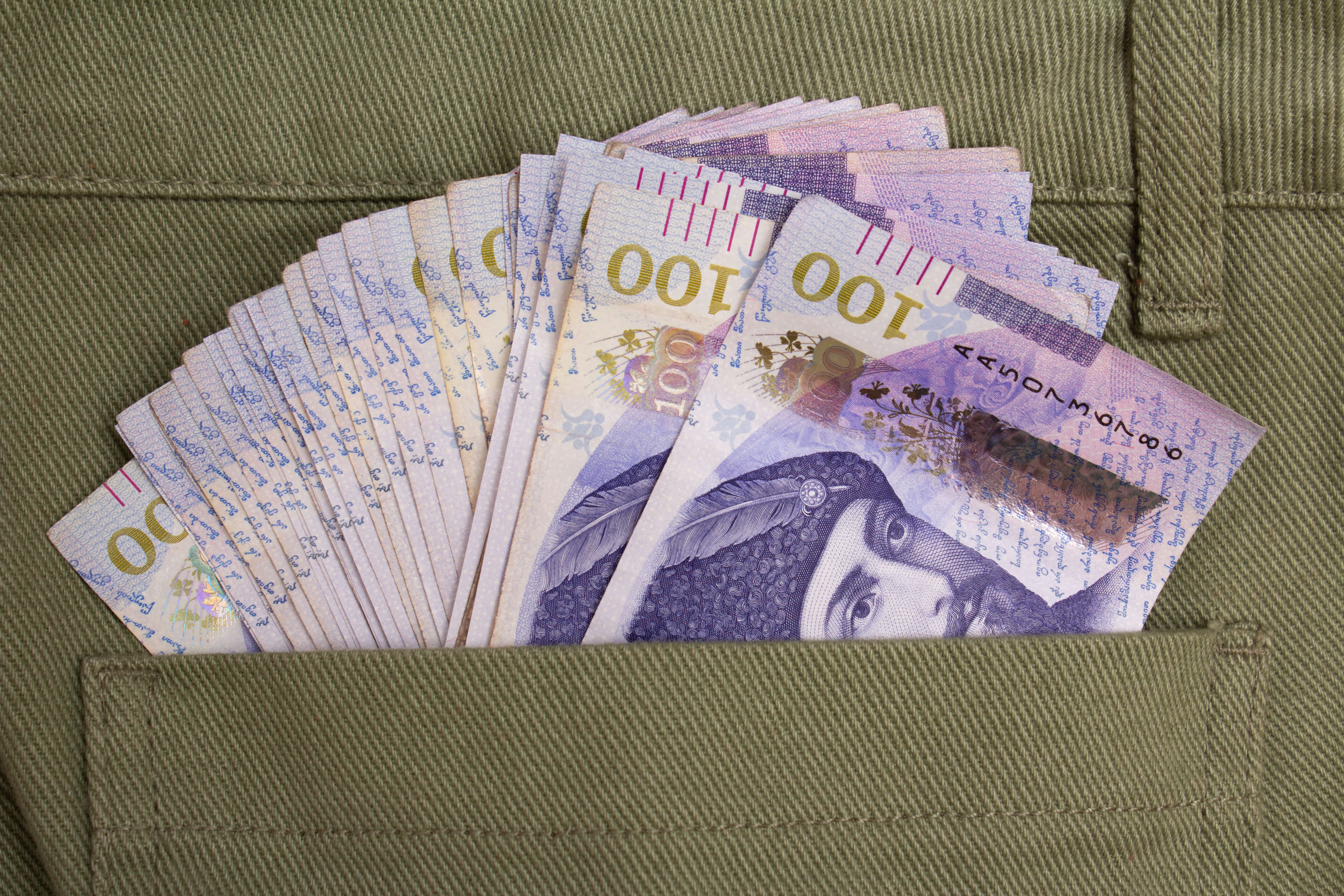 A spread of Georgian banknotes partially visible inside a pocket.