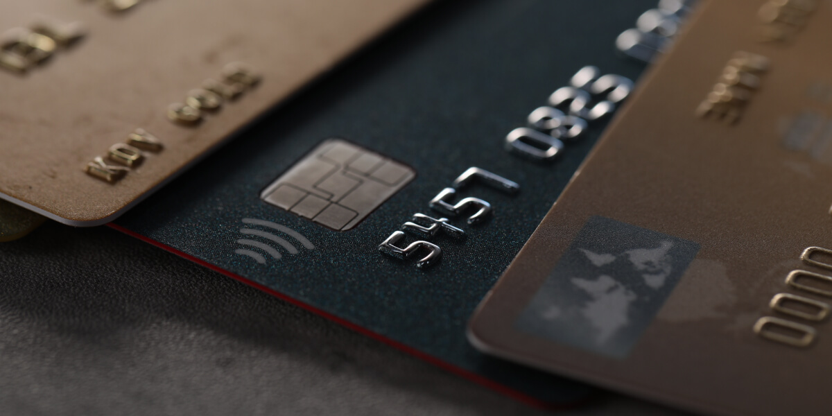 A detailed view of two stacked credit cards, highlighting the chip and embossed numbers.