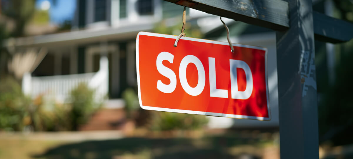 A bright red "SOLD" sign in front of a house, indicating successful property transactions in Florida.