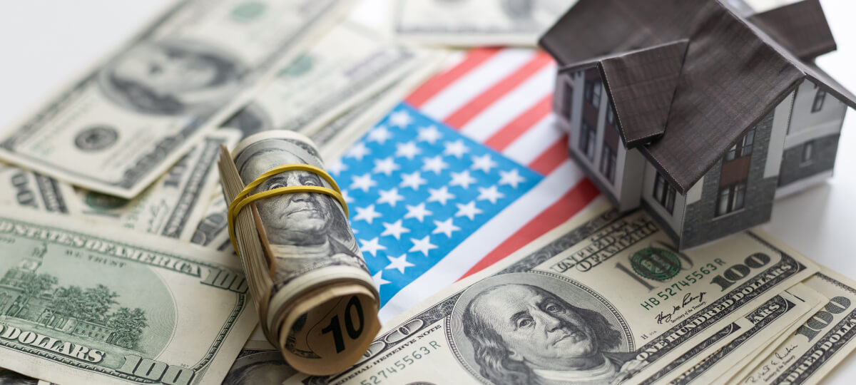 Rolled dollar bills and the U.S. flag symbolizing financial investments in Florida's economy.