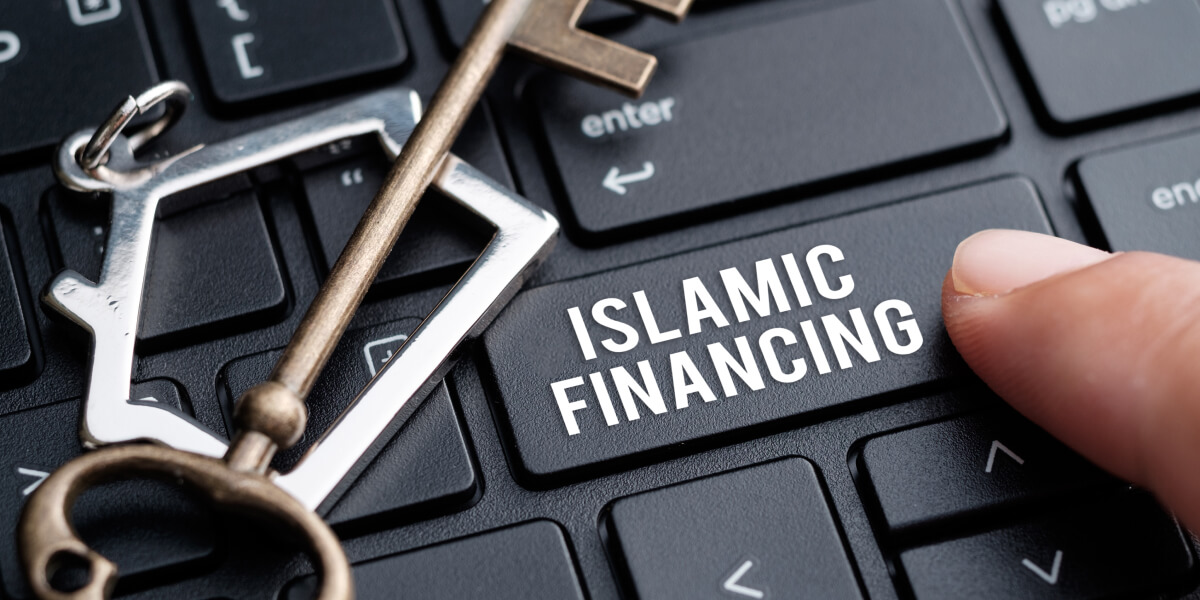 A keychain in the shape of a house resting on a keyboard with the words "ISLAMIC FINANCE" visible.