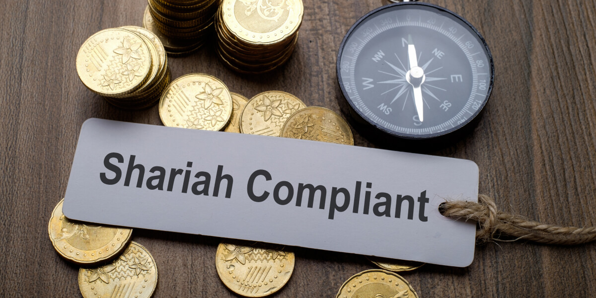 Stacks of gold coins placed beside a sign that reads "Shariah Compliant."