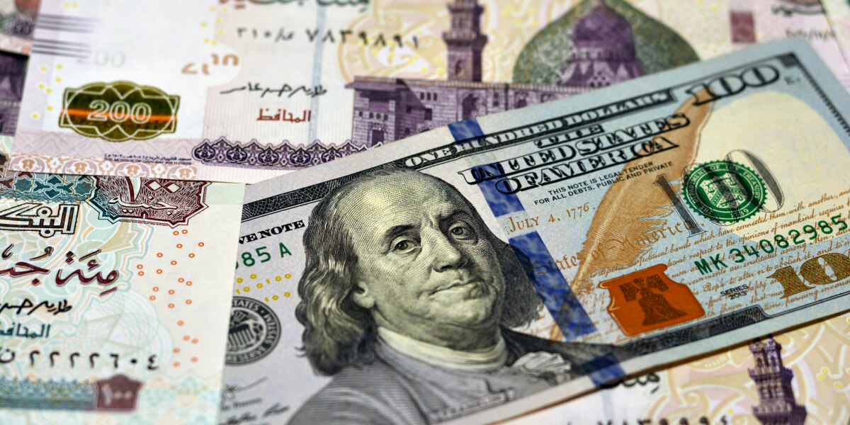 A close-up image of a US dollar bill overlapping with a UAE dirham note, symbolizing international currency exchange or financial relations.