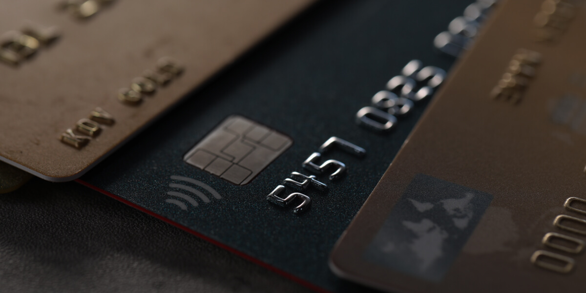 Close-up of stacked credit cards, highlighting chip technology and contactless payment symbol.