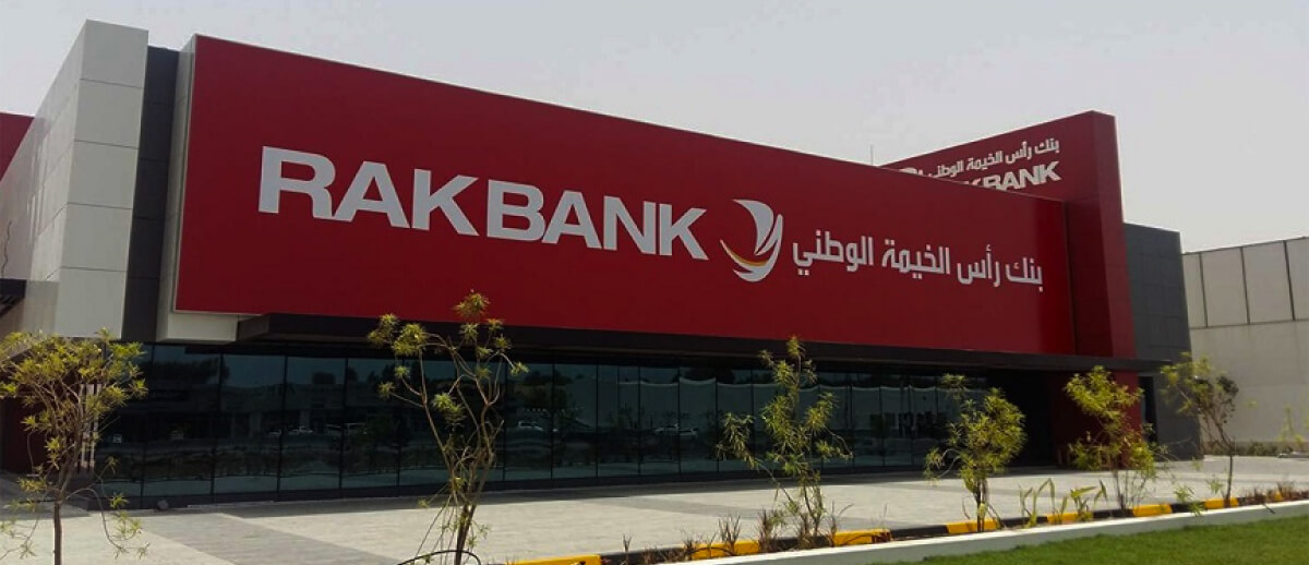 A red building sign of RAKBANK with the logo and Arabic text.