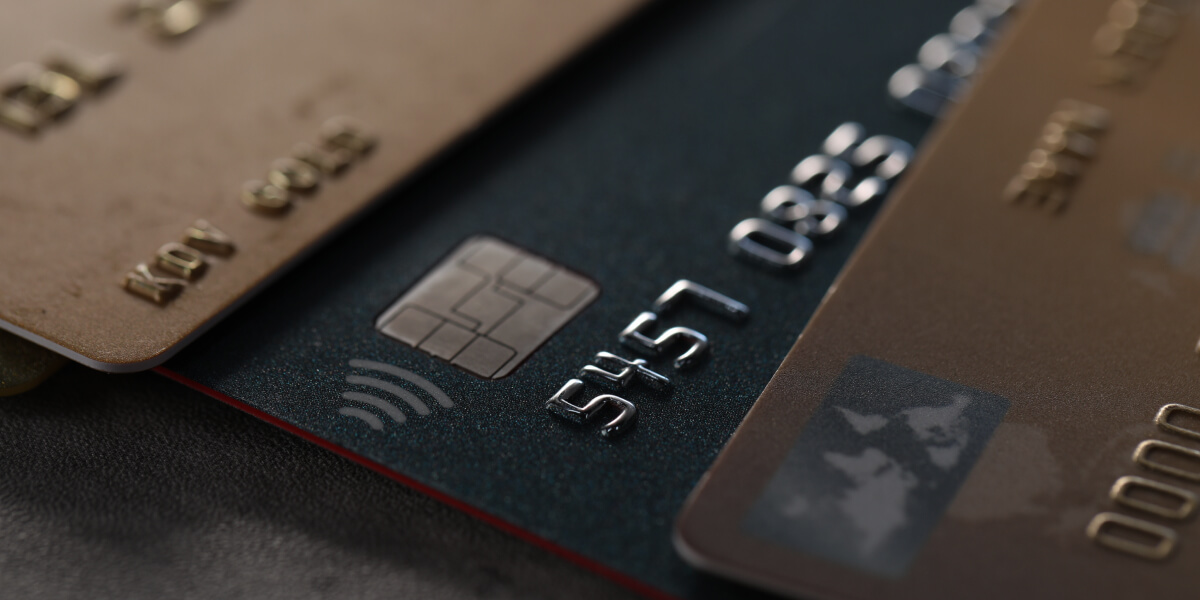 Macro shot of metallic credit cards showing chip and contactless symbol.