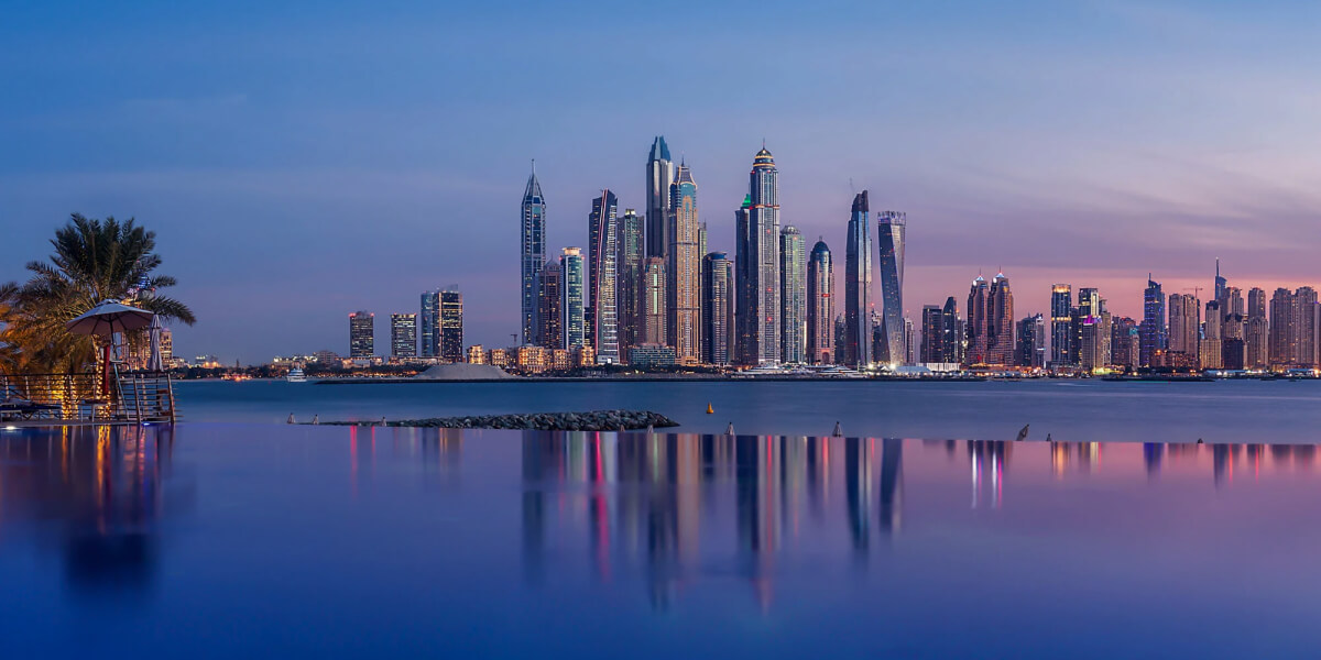 Dubai Marina skyline at dusk with reflections in an infinity pool.