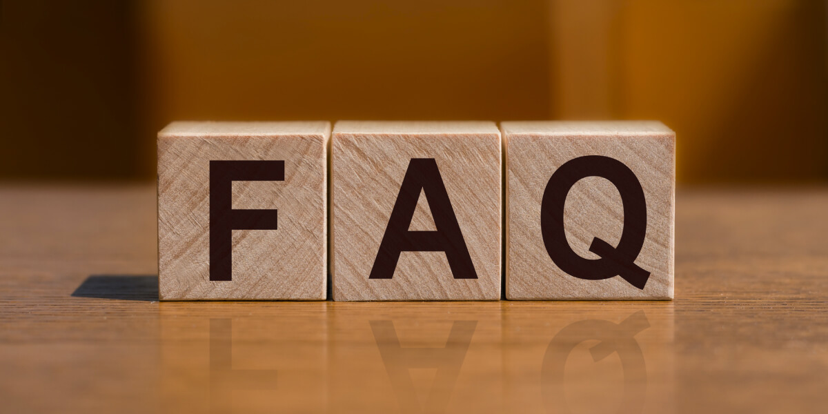 Wooden blocks with large black letters spelling out "FAQ" for frequently asked questions.
