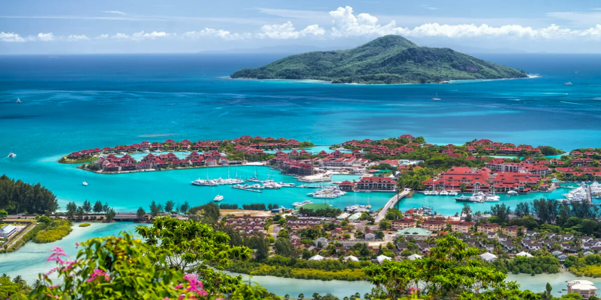 Red-roofed villas dot the coastline of a luxury island resort in the Seychelles.