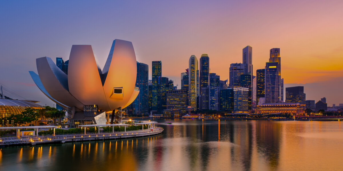 The lotus-shaped ArtScience Museum stands out against Singapore’s cityscape at sunset.