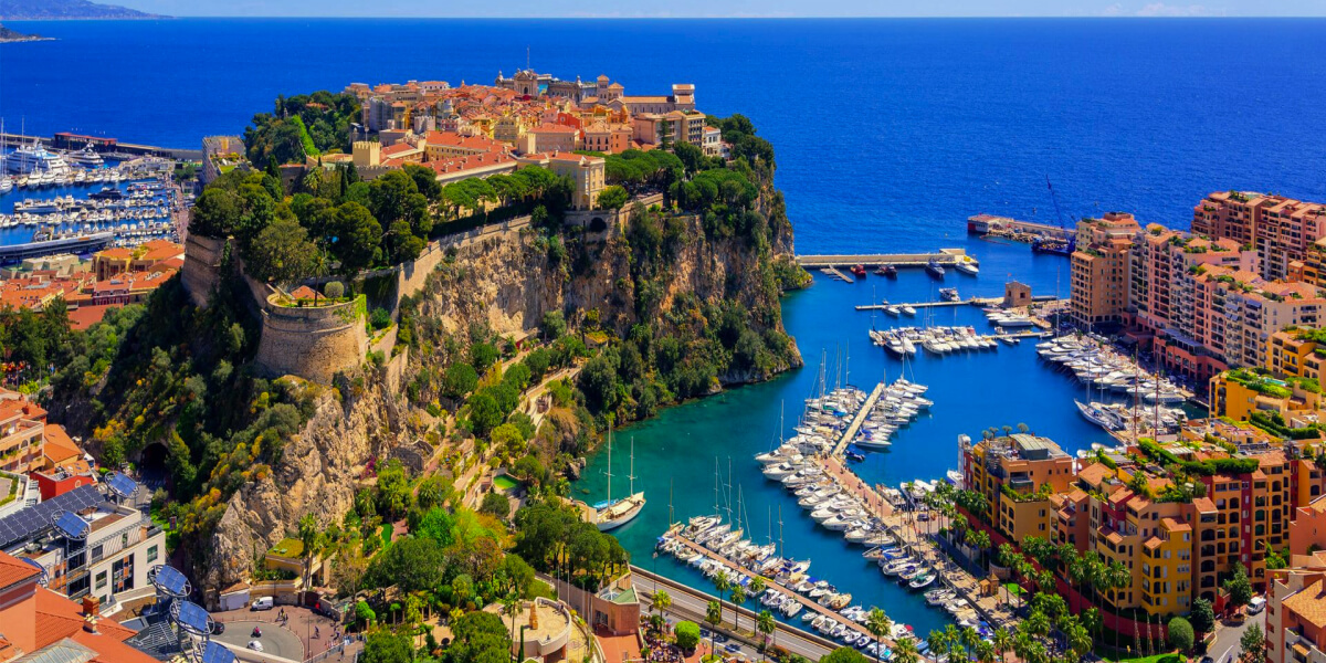 Monaco’s historic city sits atop a cliff overlooking a marina filled with yachts.
