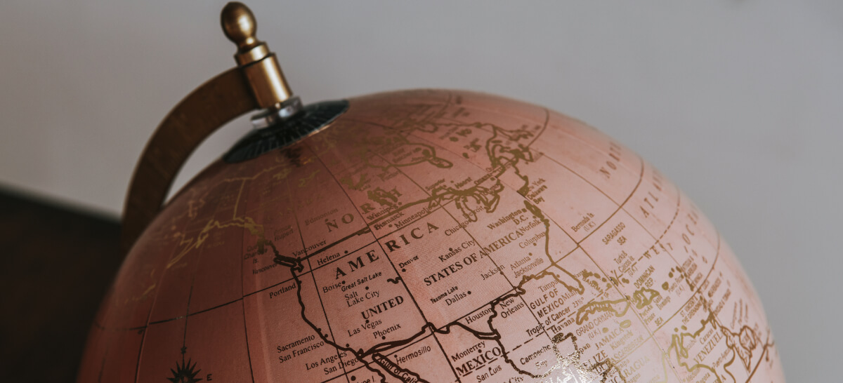 A close-up of a vintage-style globe displaying North America with gold-toned markings.
